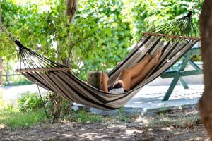 a woman laying in a hammock in a park at Hotel Sarikas in Polychrono