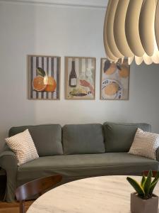 a living room with a green couch and pictures on the wall at Casa Di Sabbia Air-bnb in Nafpaktos