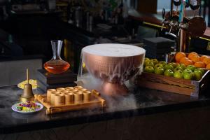 a counter with a juicer and some apples and oranges at Renaissance Riverside Hotel Saigon in Ho Chi Minh City