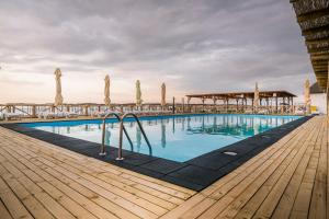 ein Swimmingpool am Strand mit Holzterrasse in der Unterkunft Gura Portitei Resort in Jurilovca
