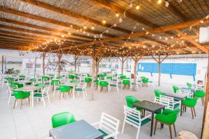 eine Terrasse mit Tischen, Stühlen und Lichtern in der Unterkunft Gura Portitei Resort in Jurilovca