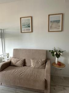a couch in a living room with two pictures on the wall at Benalbeach Playa in Benalmádena