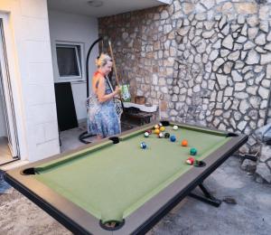 a woman standing next to a pool table at Casa Blanca White House in Okrug Donji