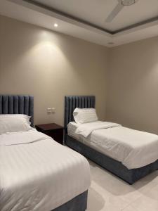 two beds sitting next to each other in a bedroom at أعمال الهاشم للشقق المخدومة الوجه Al Hashem for Served Apartments in Al Wajh +31 photos