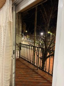 eine offene Tür zu einem Balkon in der Nacht in der Unterkunft Departamento en pleno centro in San Miguel del Monte + 1 Foto
