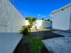a patio with a white wall and a chair at Noulakaz Maison proche Belle Mare marché de Flacq in Argy +27 photos