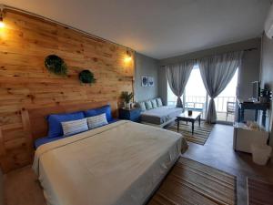 a bedroom with a large bed with a wooden wall at บ้านฟ้าใส รีสอร์ท เกาะล้าน in Ko Larn