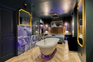a bathroom with a bath tub and a bed at La Suite Versailles freeParking table massage Clim in Montreuil +20 photos