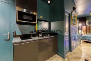 a kitchen with green walls and a sink and a bed at La Suite Versailles freeParking table massage Clim in Montreuil