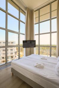 a bedroom with a large bed with large windows at Porta Mare Active & Spa Resort in Dziwnówek +73 photos