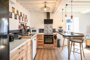 a kitchen with a table and a stove top oven at A Fleur de Quai - Vue sur le port in Isigny-sur-Mer +4 photos