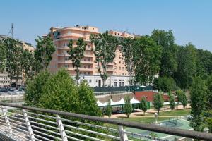 a large building in front of a park with trees at Flora Guest House in Rome