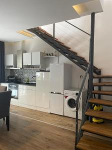 a kitchen with white cabinets and a staircase at North Star - sea apartment in Balchik