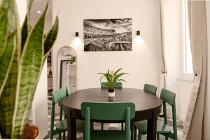 a dining room with a wooden table and green chairs at Flora Guest House in Rome