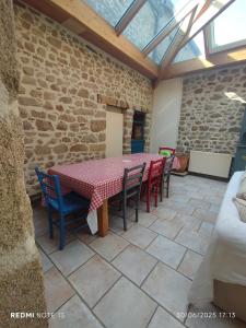 a patio with a table and chairs in a stone wall at La loutre - 8 personnes in Mortagne-sur-Sèvre