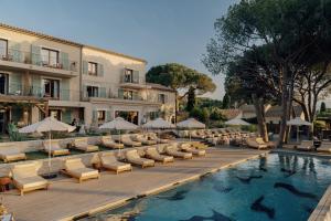a resort with a pool and lounge chairs and a building at Boutique Hôtel Responsable et Restaurant Basgi Basgi in Saint-Florent