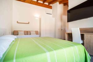 a bedroom with a green bed and a couch at Luxury Home La Cinta in San Teodoro