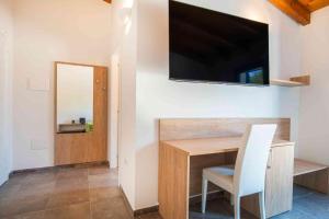a room with a desk with a television on a wall at Luxury Home La Cinta in San Teodoro