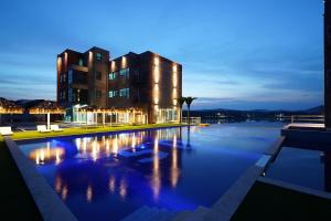 a building with a swimming pool at night at Hotel Opus in Gyeongju
