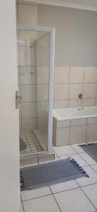 a bathroom with a shower and a tub and a sink at Cleo's Corner in East London