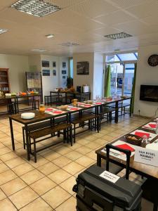 a room with tables and chairs in a room at Hotel Du Rocher in Le Caylar