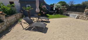 twee stoelen en een paraplu in een tuin bij Niki in Punta Križa