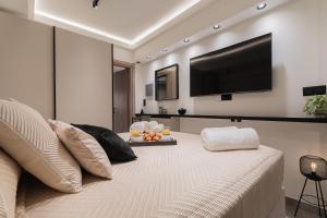 ein Schlafzimmer mit einem großen Bett und einem Flachbildfernseher in der Unterkunft Monte Smith Luxury Suites in Rhodos (Stadt)