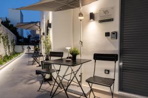a patio with a table and chairs and an umbrella at Monte Smith Luxury Suites in Rhodes Town