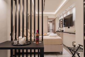 a bedroom with a bed and a table with a bottle of wine at Monte Smith Luxury Suites in Rhodes Town