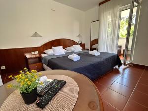 a hotel room with a bed and a remote control at Guest House Sol 1 in Cavtat