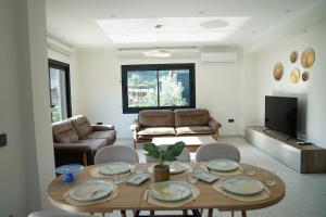 a living room with a table and chairs and a couch at Orange Tree Villa, Happy Tree Houses in Dalaman