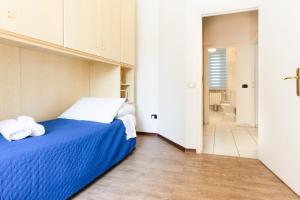 a bedroom with a blue bed with towels on it at Il Ciliegio - Casa Vacanza Macerata in Macerata