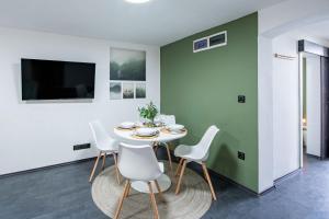a dining room with a white table and chairs at Central - Green - Stylish - Quiet Sleep in Debrecen