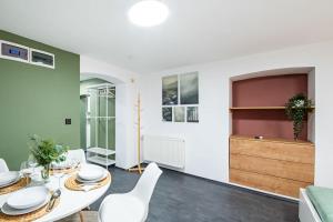a dining room with a white table and white chairs at Central - Green - Stylish - Quiet Sleep in Debrecen