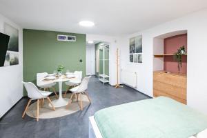a room with a table and chairs and a bed at Central - Green - Stylish - Quiet Sleep in Debrecen +21 photos