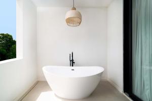 a white bath tub in a bathroom with a window at New Stylish 3BR with Private Pool ! Walk to Beach in Saint James