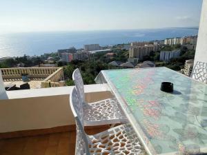 a table and chairs on a balcony with the ocean at Appartement Vue Mer à Bastia, terrasse et piscine privée. in Bastia +82 photos