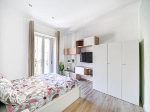 Un dormitorio blanco con una cama y un televisor. en Casa Vacanze Ninina, en Nápoles