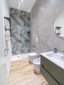 Un baño con inodoro, lavabo y espejo. en Casa Vacanze Ninina, en Nápoles