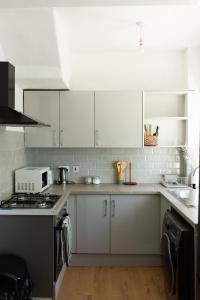 a kitchen with white cabinets and a stove top oven at An entire 3 Bedroom house in Beeston United Kingdom in Beeston