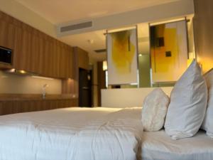 a bed with white sheets and pillows in a room at The hotel residences at Acqua in Manila +12 photos