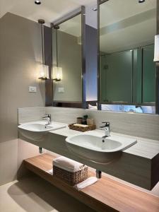 a bathroom with two sinks and a large mirror at The hotel residences at Acqua in Manila +11 photos