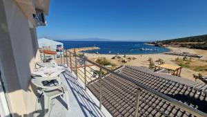 a balcony with a view of a beach and the ocean at Aegean Horizon Apartment in Skala Marion