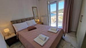 a bedroom with a bed with two towels on it at Aegean Horizon Apartment in Skala Marion