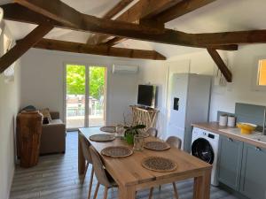 Una cocina con una mesa de madera y un comedor. en Airial landais, en Mimizan