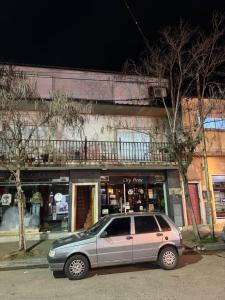 ein silbernes Auto, das vor einem Geschäft parkt in der Unterkunft Departamento en pleno centro in San Miguel del Monte