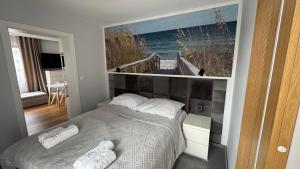 Un dormitorio con una cama con un cuadro en la pared. en ANNA rooms and apartments, en Mielno