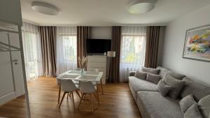 una sala de estar con un sofá y una mesa en ANNA rooms and apartments, en Mielno