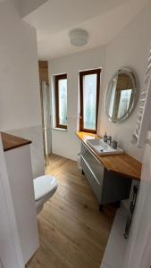 Un baño con lavabo, inodoro y espejo. en ANNA rooms and apartments, en Mielno 39 fotos más