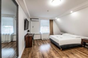 a bedroom with a bed and a mirror at Noclegi Europa in Bolesławiec
